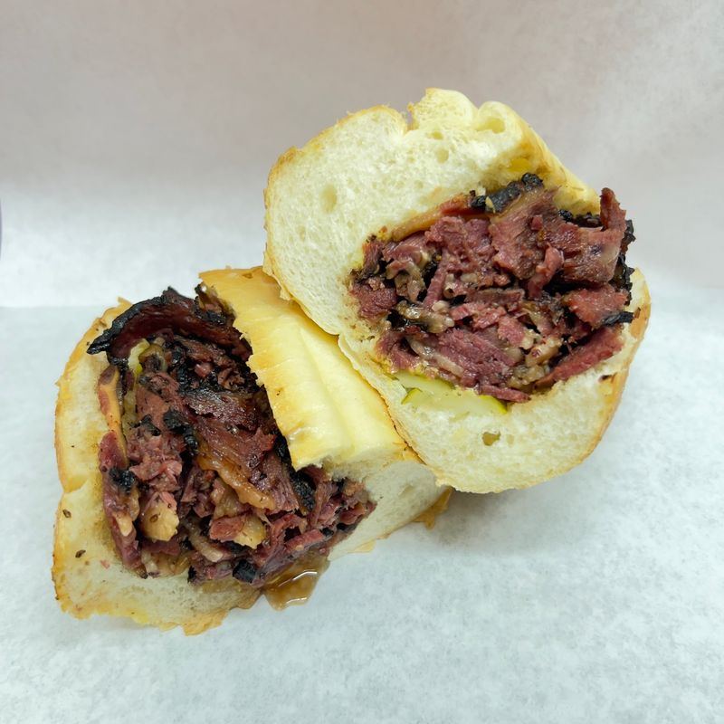 Classic Chicago pastrami sandwich cut in half, piled with pastrami on a hoagie roll