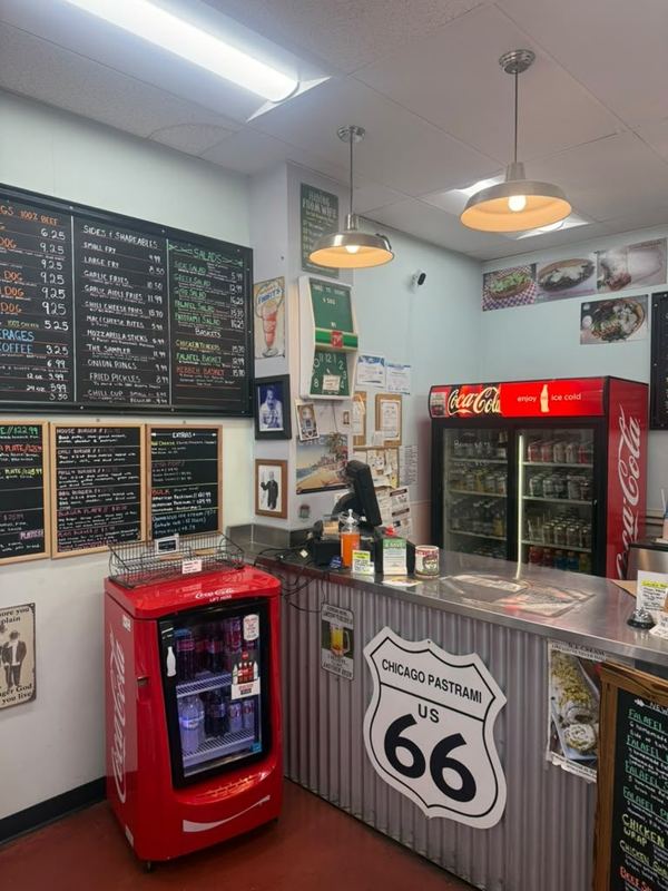 The order counter with a Chicago Pastrami Route 66 sign, chalkboard menus and Coca-Cola coolers